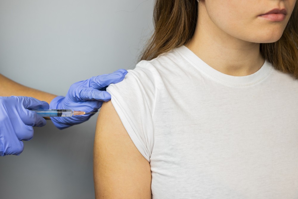 Odczulanie młodej kobiety za pomocą szczepionki w ramię przez lekarza